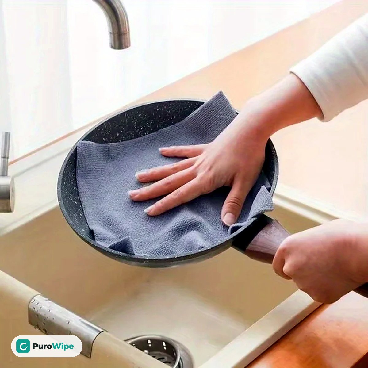 Wiping a frying pan dry with a microfiber sheet